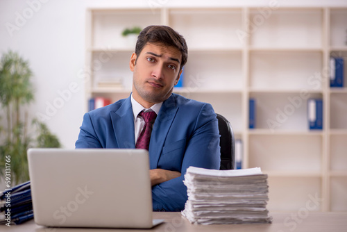 Young male employee and too much work in the office