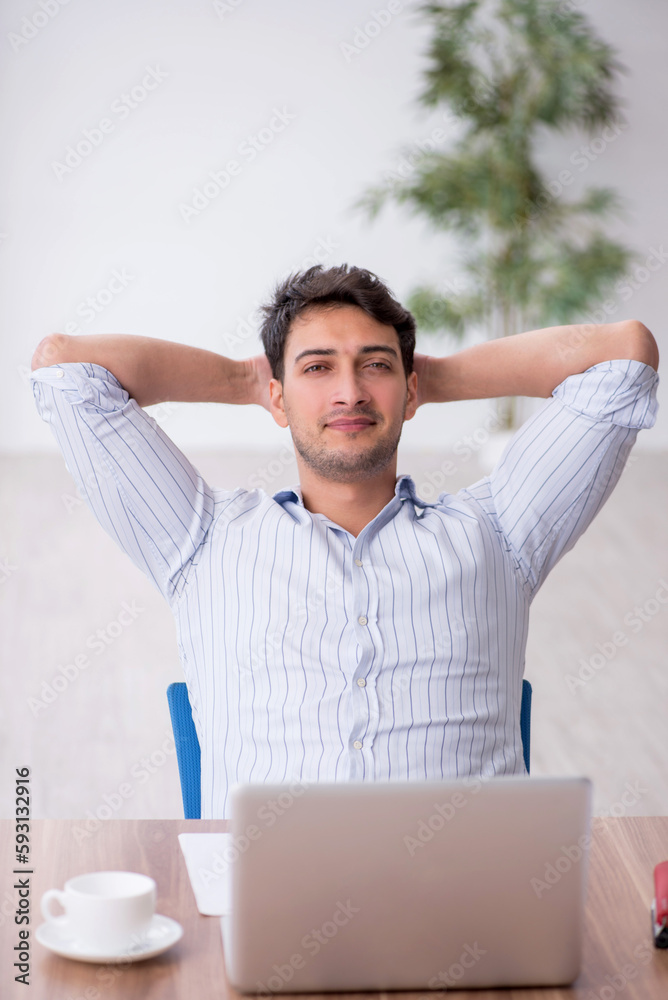Young male employee working in the office Young male employee working in the office