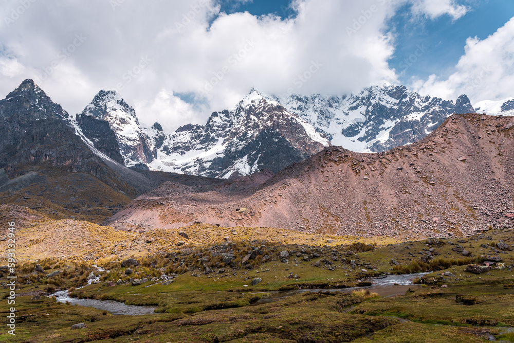 Photos of the tranquil turquoise lake and admiring the snow-capped Ausangate mountain peaks on a sunny day in Peru.