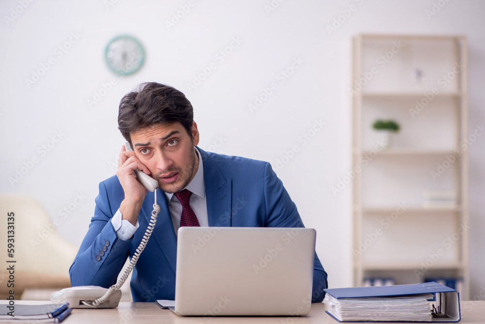 Young male employee working in the office Young male employee working in the office