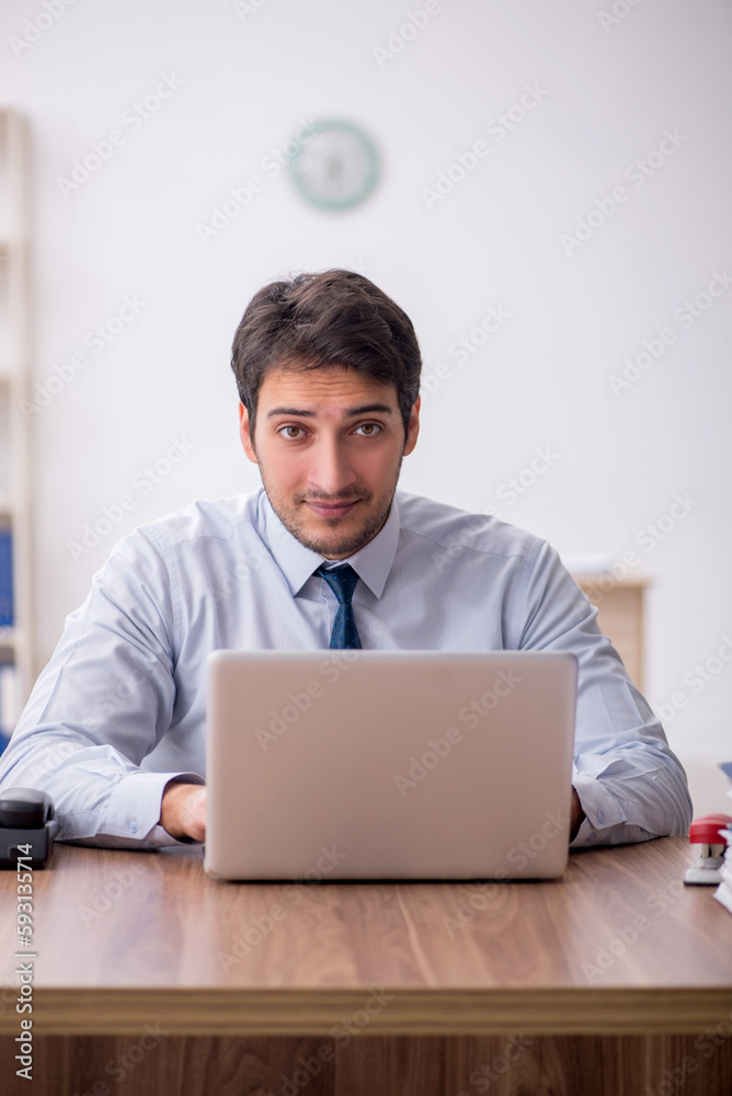 Young male employee working in the office Young male employee working in the office