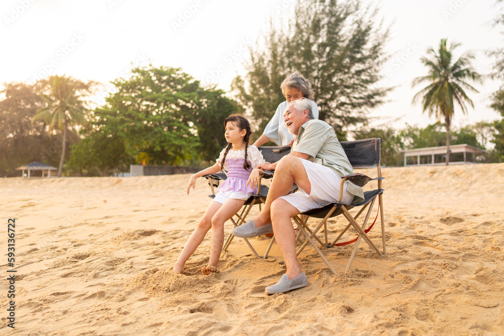 Group of Happy Multi-Generation Asian family enjoy and fun outdoor activity lifestyle resting and playing together at tropical island beach during travel ocean at sunset on summer holiday vacation.