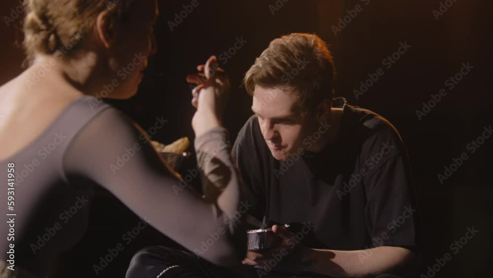 Pair of tired ballet dancers sit on theatre stage and discuss ...