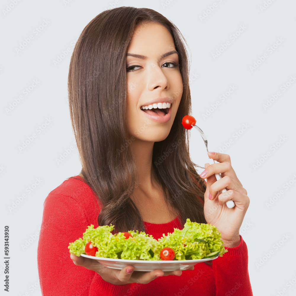 Square image of smiling asian caucasian woman in red casual cloth, sweater, holding salad plate, isolated light grey gray background. Brunette girl. Keto ketogenic dieting, weight loss, healthy eating Square image of smiling asian caucasian woman in red casual cloth, sweater, holding salad plate, isolated light grey gray background. Brunette girl. Keto ketogenic dieting, weight loss, healthy eating