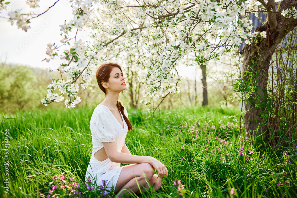 Young beautiful woman in a white dress posing in garden Young beautiful woman in a white dress posing in garden