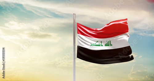 Iraq national flag waving in beautiful sky. The symbol of the state on wavy silk fabric.