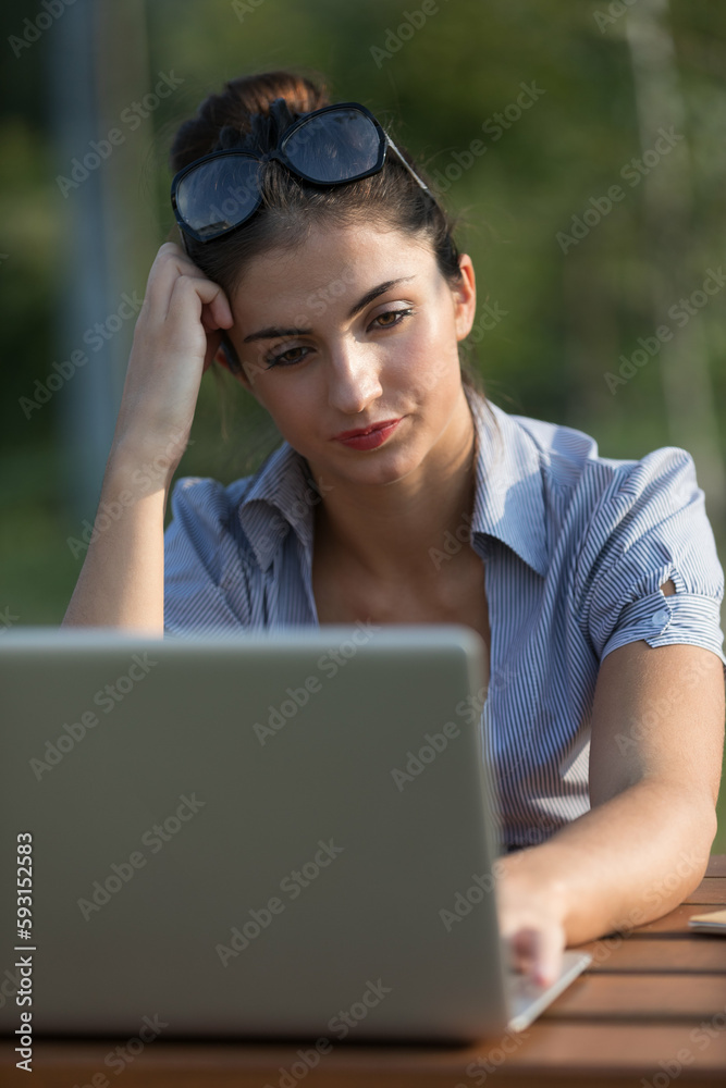 Unhappy student or worker, laptop outdoors Unhappy student or worker, laptop outdoors
