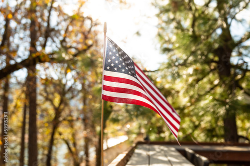United States Flag on a Cabin in the Woods Backlit by the Sun on a Beautiful Sunny Day