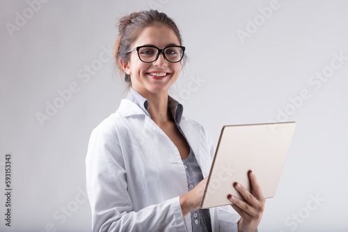 Smiling woman, lab coat, glasses, digital tablet, positive situa photo