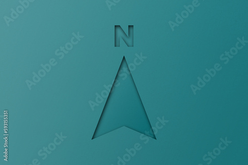 Green paper cut shape north arrow set on green paper background.