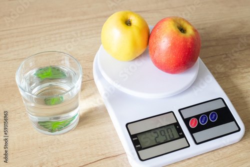 Fresh red apples on white kitchen scales in the kitchen view from above. The concept of proper nutrition and healthy lifestyle