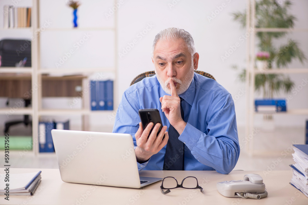 Old male employee working in the office Old male employee working in the office