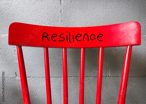 Red chair with handwritten RESILIENCE, means capacity to recover quickly from difficulties and toughness - ability to cope crisis and spring back to normal quickly