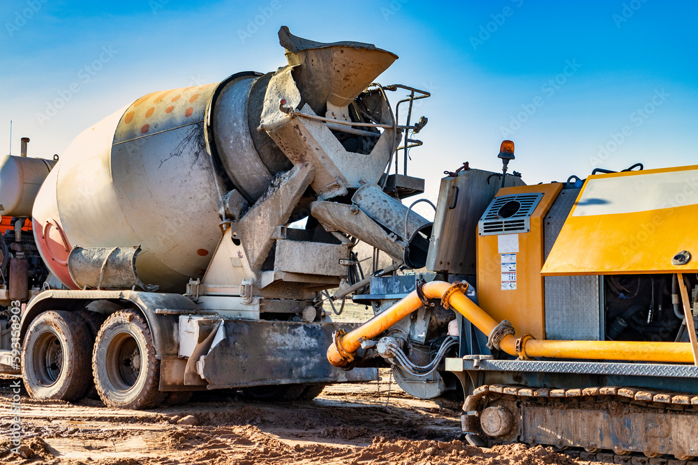 Concrete mixer truck delivers concrete to the pump for pouring piles. Concrete pump at the construction site. Close-up of concrete delivery.