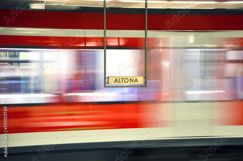 Altona station sign and passing by train behind it. photo