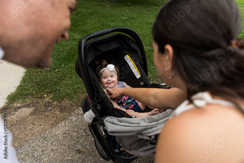 Obraz na płótnie Parents looking at special needs infant in carseat