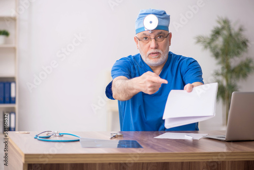 Old male doctor otologist working in the clinic