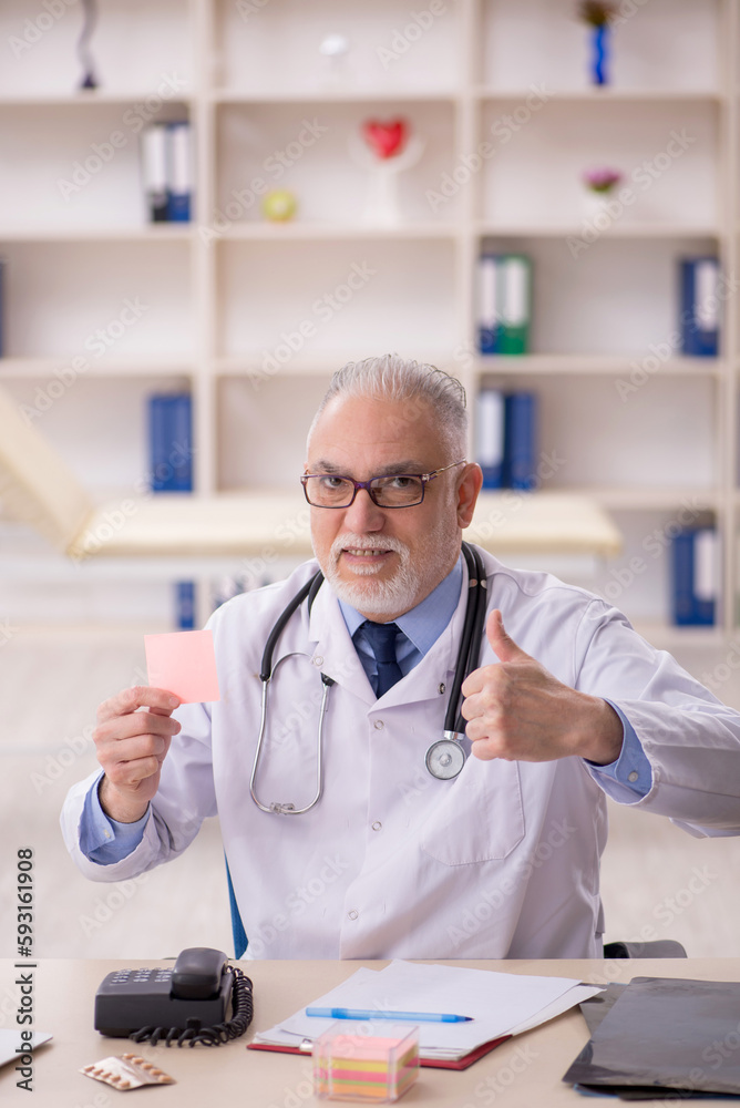 Old male doctor working in the clinic Old male doctor working in the clinic