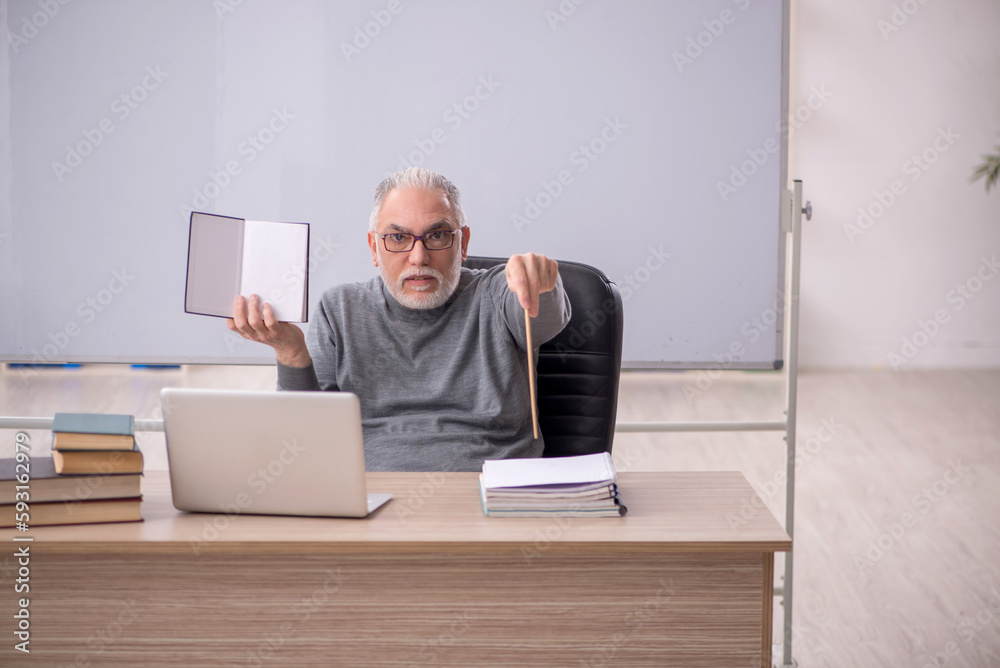 Old male teacher in the classroom Old male teacher in the classroom