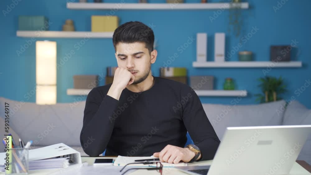 Worried businessman is working in his home office and his business is not going well. Businessman working from home is stressed and overwhelmed with work. Worried businessman is working in his home office and his business is not going well. Businessman working from home is stressed and overwhelmed with work.