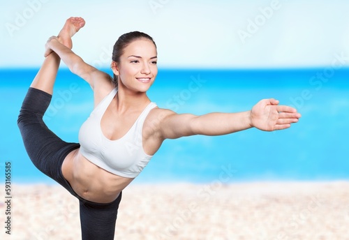 Young happy woman in yoga pose and meditation on beach.