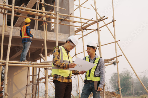 Team of engineer and worker checking construction site outdoors Surveyor builder Engineer surveying work checking schedule for rebuilding project.