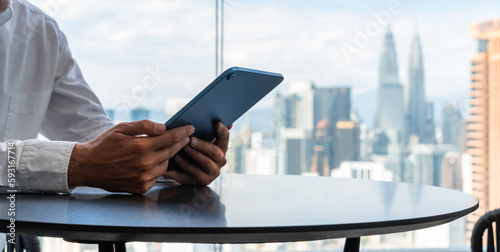 Photography Businessman hands holding tablet, online business and Kuala Lumpur buildings