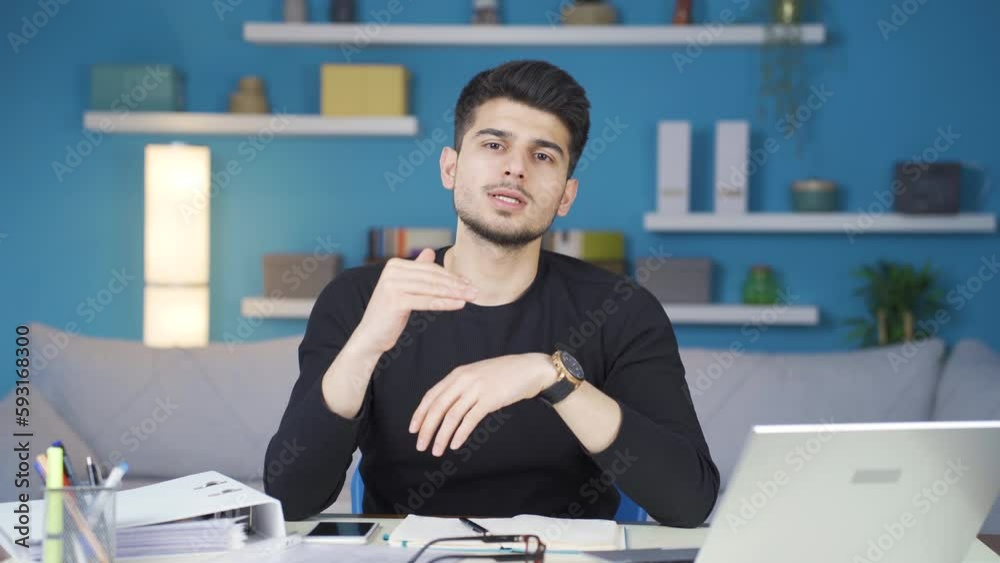 Young man speaking to camera is telling good results about business. Happy and elegant young business man informs about progress of business from home office. Young man speaking to camera is telling good results about business. Happy and elegant young business man informs about progress of business from home office.