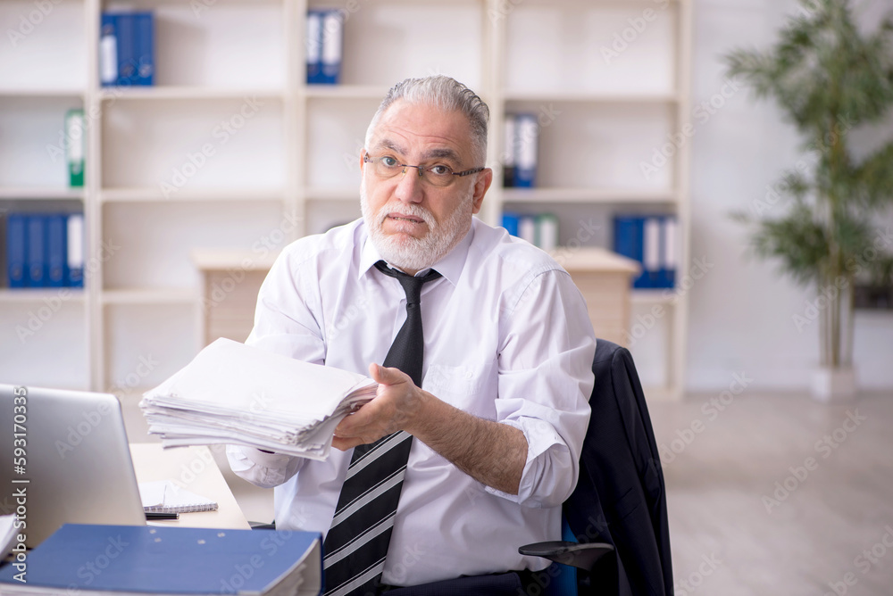 Old male employee and too much work at workplace Old male employee and too much work at workplace