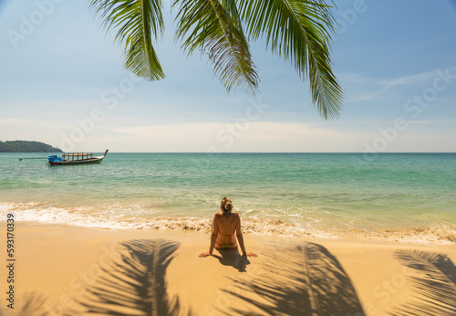 Traveler woman sitting on the beach enjoying the landscape and t photo