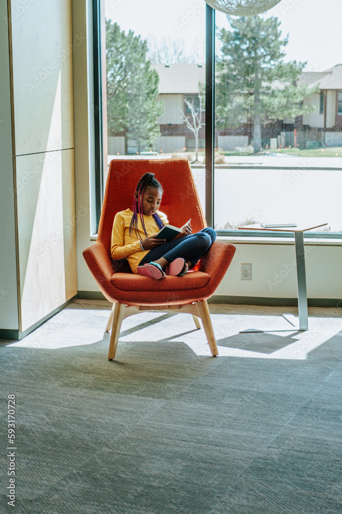 Young girl reading a book in a sunny corner Young girl reading a book in a sunny corner