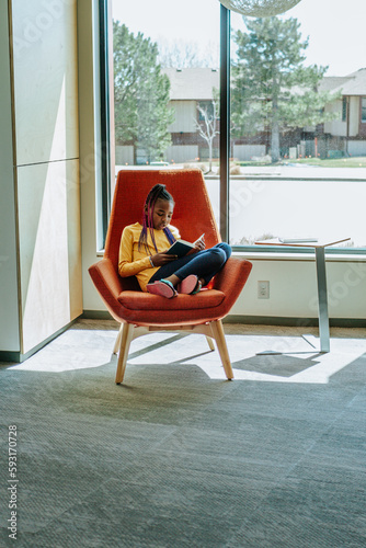 Wallpaper Mural Young girl reading a book in a sunny corner Torontodigital.ca