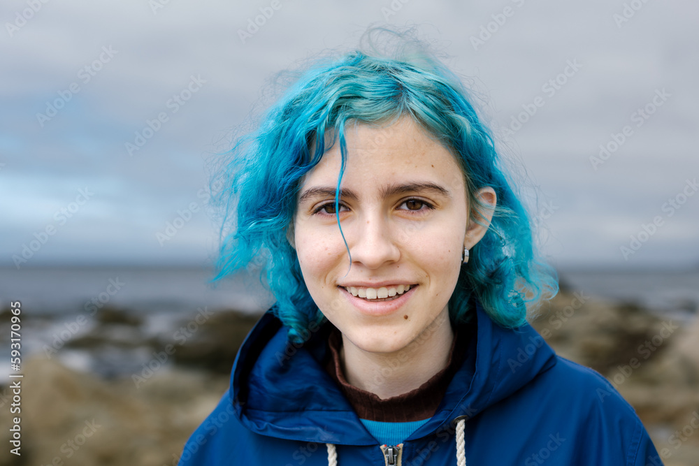 Teen Girl With Blue Hair Smiles At Camera While At The Coast Teen Girl With Blue Hair Smiles At Camera While At The Coast