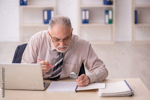 Old male employee working in the office