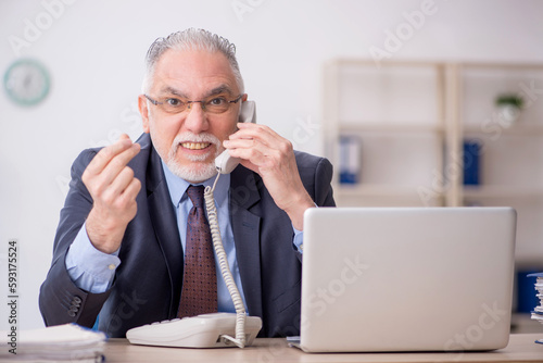 Old male employee working in the office