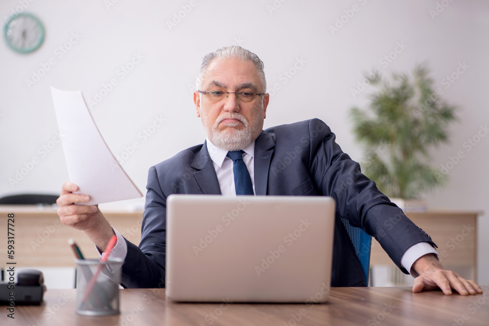 Old male employee working in the office Old male employee working in the office
