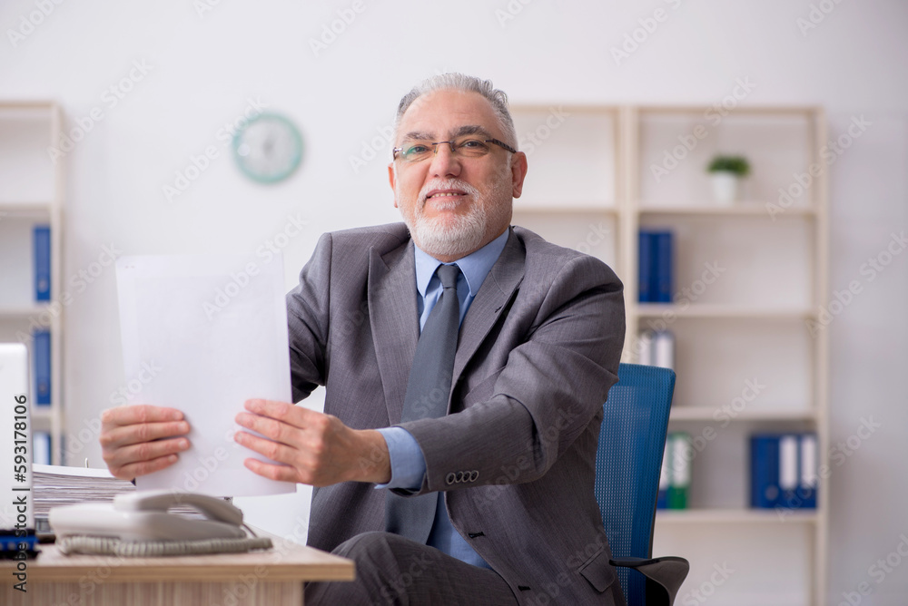 Old male employee working in the office Old male employee working in the office