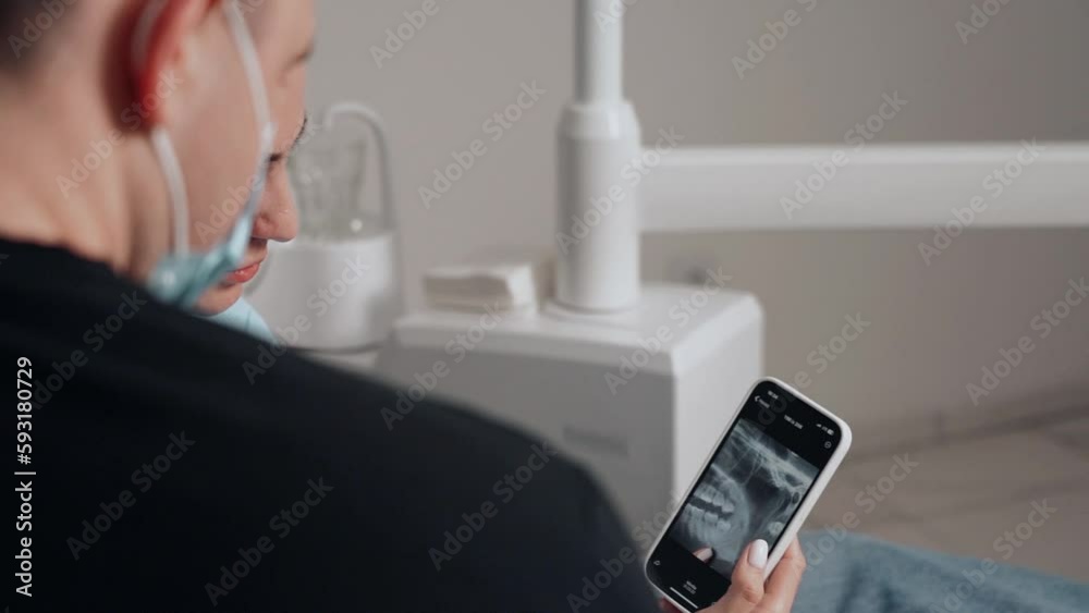 Two doctors, man and woman in protective masks in a dental clinic, serve the patient girl. Work Dentist. Healthcare and medicine concept.