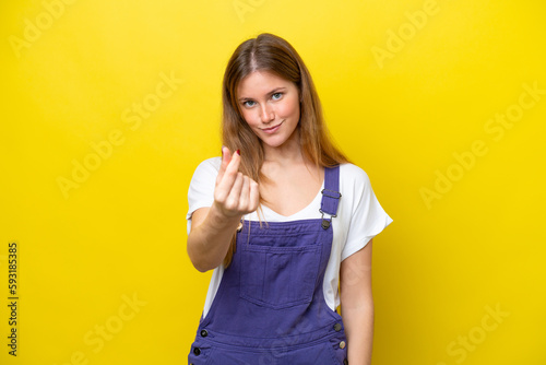 Young caucasian woman isolated on yellow background making money gesture