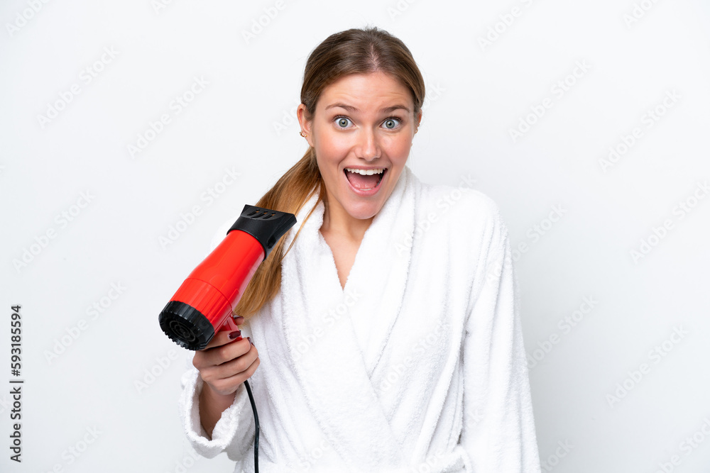 Young caucasian woman holding hairdryer isolated on white background with surprise and shocked facial expression Young caucasian woman holding hairdryer isolated on white background with surprise and shocked facial expression
