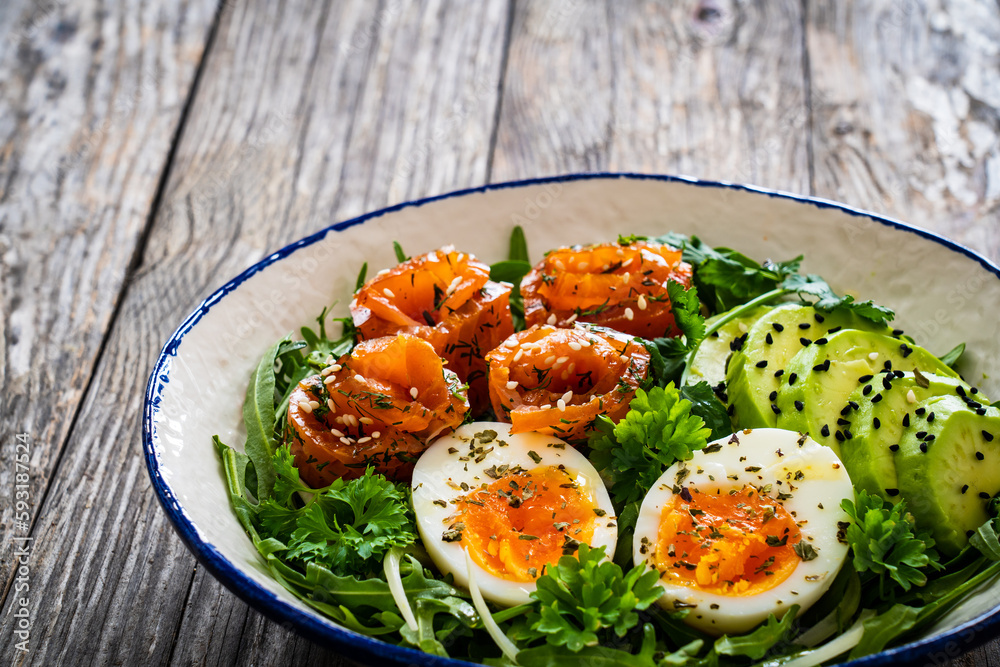 Salmon salad - smoked salmon, hard boiled eggs, avocado and leafy greens on wooden table
Salmon salad - smoked salmon, hard boiled eggs, avocado and leafy greens on wooden table