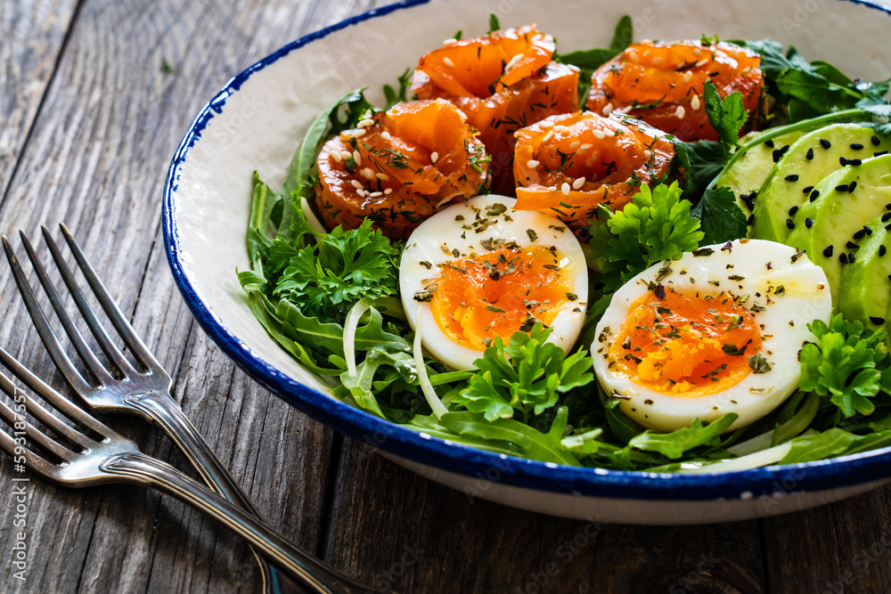 Salmon salad - smoked salmon, hard boiled eggs, avocado and leafy greens on wooden table
Salmon salad - smoked salmon, hard boiled eggs, avocado and leafy greens on wooden table