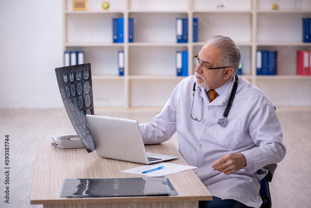 Old male doctor radiologist working in the clinic