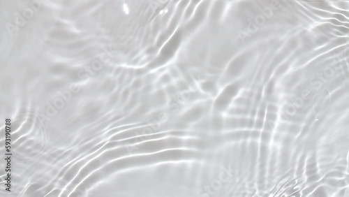 Pure water with reflections sunlight in slow motion. Water surface texture top view. Sun and shadows. Motion clean swimming pool ripples and wave. High quality 4k footage