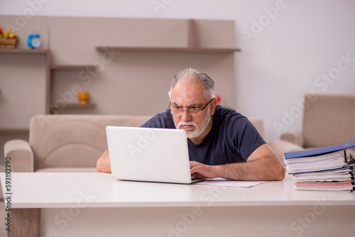 Old male employee working from home during pandemic