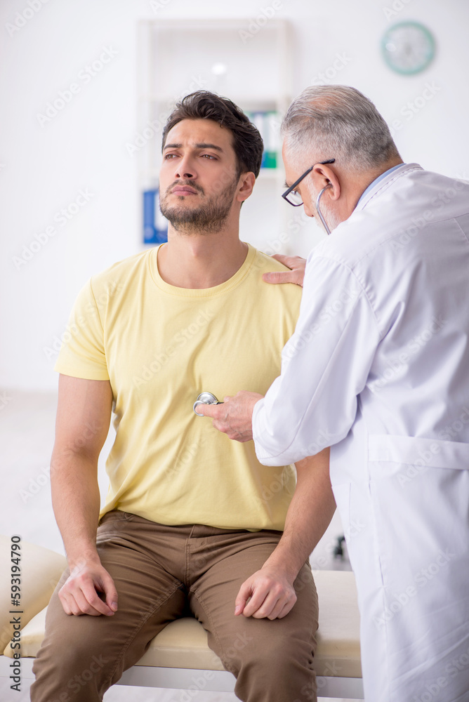 Young male patient visiting old male doctor Young male patient visiting old male doctor