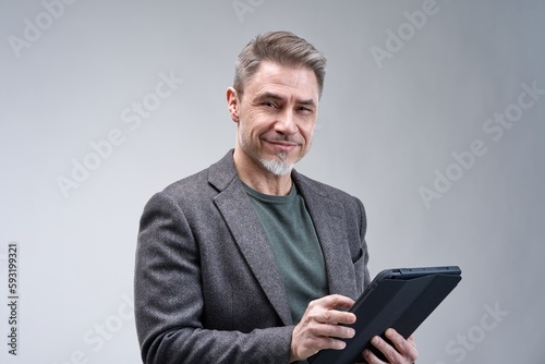 Middle age businessman in business casual using tablet computer. Entrepreneur in jacket. Portrait of mid adult, mature age man, happy smiling. Isolated on white.