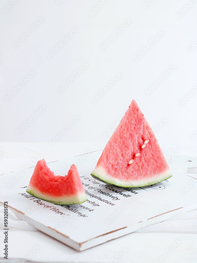 Vertical shot of slices of watermelon on a white wooden board on a white background Vertical shot of slices of watermelon on a white wooden board on a white background