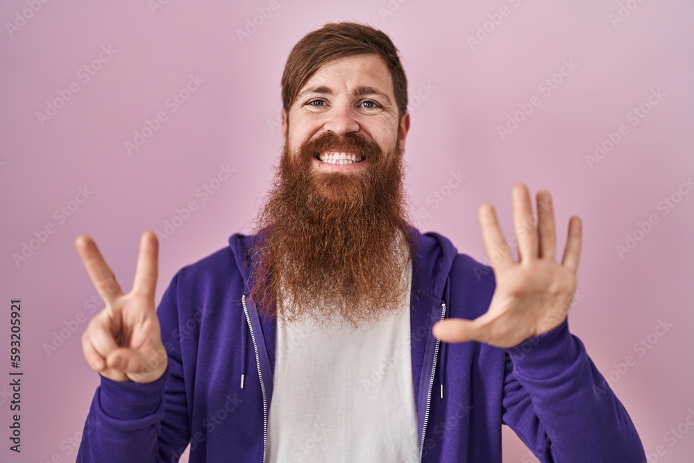 Caucasian man with long beard standing over pink background showing and pointing up with fingers number seven while smiling confident and happy. Caucasian man with long beard standing over pink background showing and pointing up with fingers number seven while smiling confident and happy.