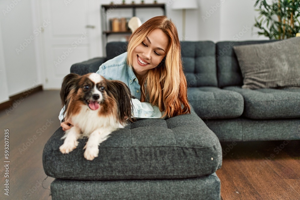 Young caucasian woman smiling confident lying on sofa with dog at home Young caucasian woman smiling confident lying on sofa with dog at home
